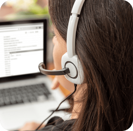 woman with headphones on in front of a laptop 